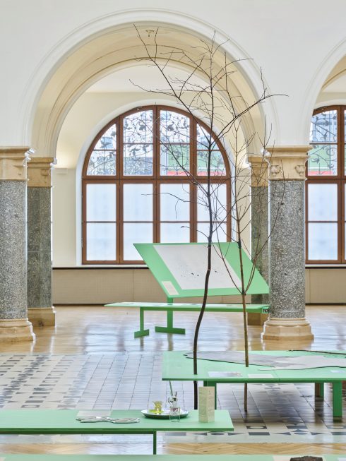 raumgreifende Installation mit Tischobjekten und Ästen