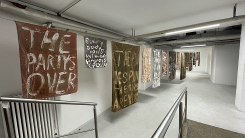 Langer Ausstellungsflur mit hängenden textilen Bannern mit Schrift