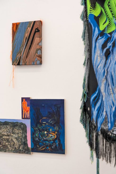 Ausstellungsansicht: Textile Wandarbeit mit gemalten Elementen, kombiniert mit kleinformatigen Gemälden.