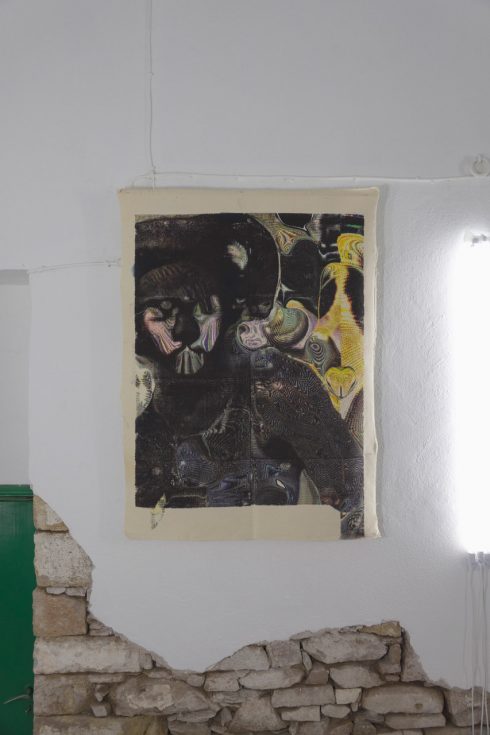 Ein Gemälde mit dunklen abstrakten Figuren hängt ohne Rahmen an einer weißen Wand.